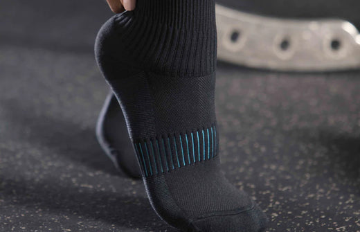Person wearing Copper Fit compression socks in a gym setting. product