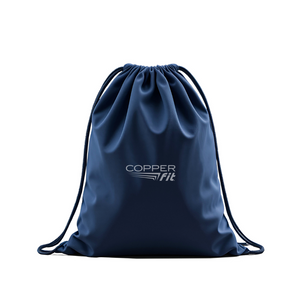 Person holding a navy drawstring bag with 'Copper Fit' logo in an indoor setting.