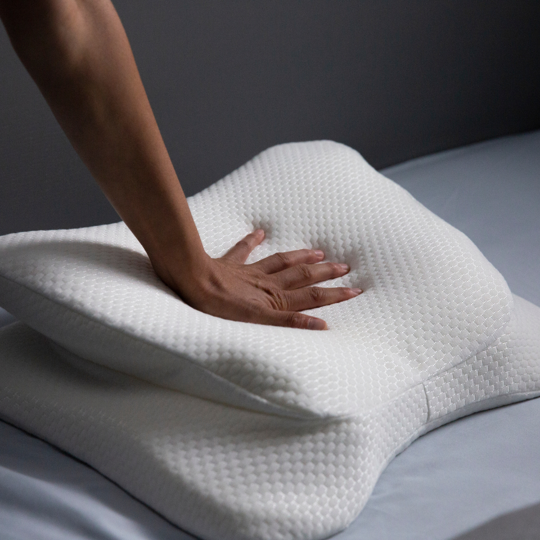 White pillow with hand on a gray surface