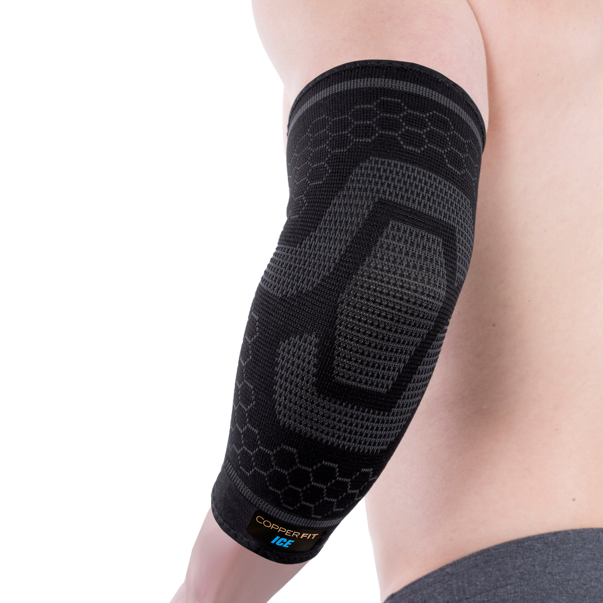 A person wearing a black ice compression elbow sleeve which has a patterned design and appears to provide support and compression.